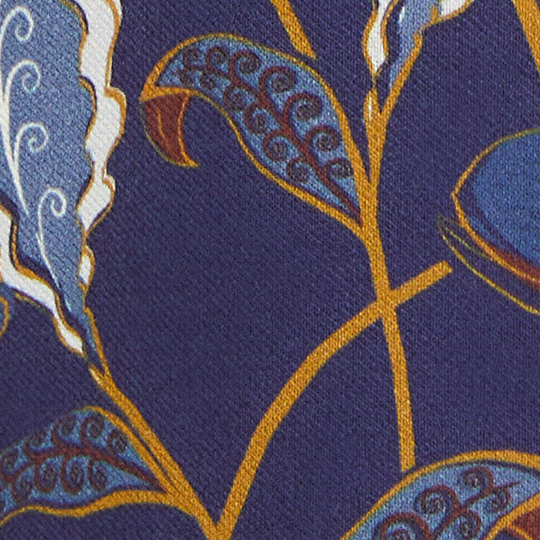Acercamiento del estampado floral y botánico del vestido, con elementos en azul, verde y amarillo.