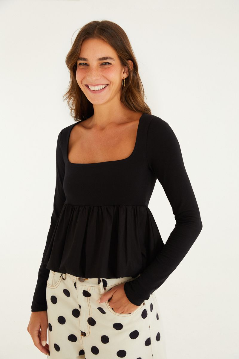 Camisa negra con mangas largas y diseño peplum vista desde el frente.