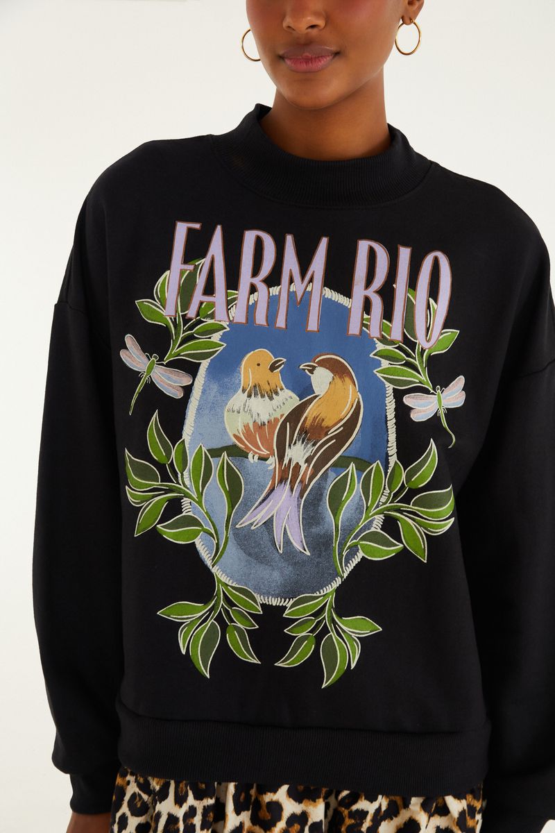 Close-up del estampado del vestido de sudadera mostrando detalles de los pájaros y hojas.