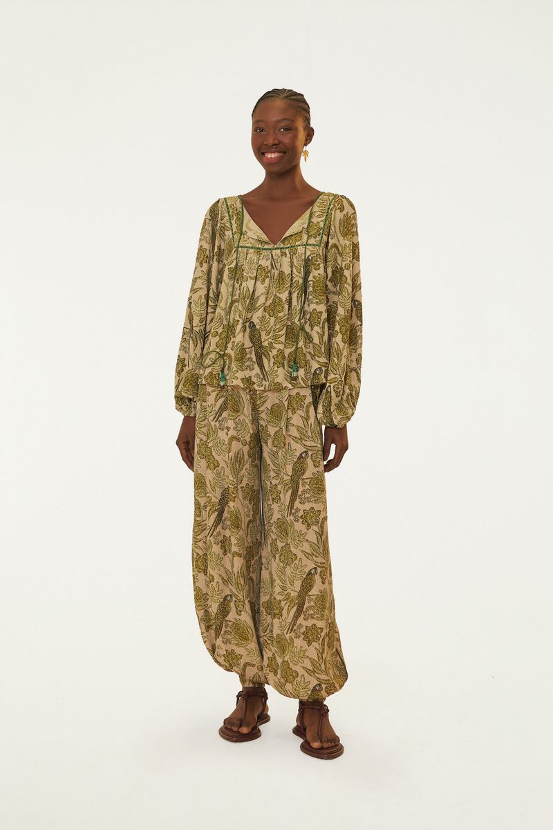 Vista frontal de un pantalón floral con estampado botánico en tonos verde claro y beige.