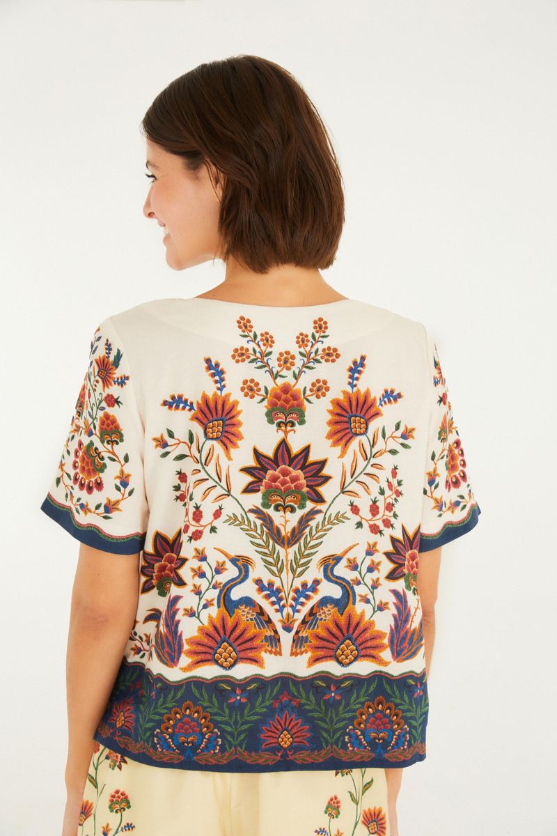 Vista trasera de la camiseta mostrando la continuidad del estampado floral.