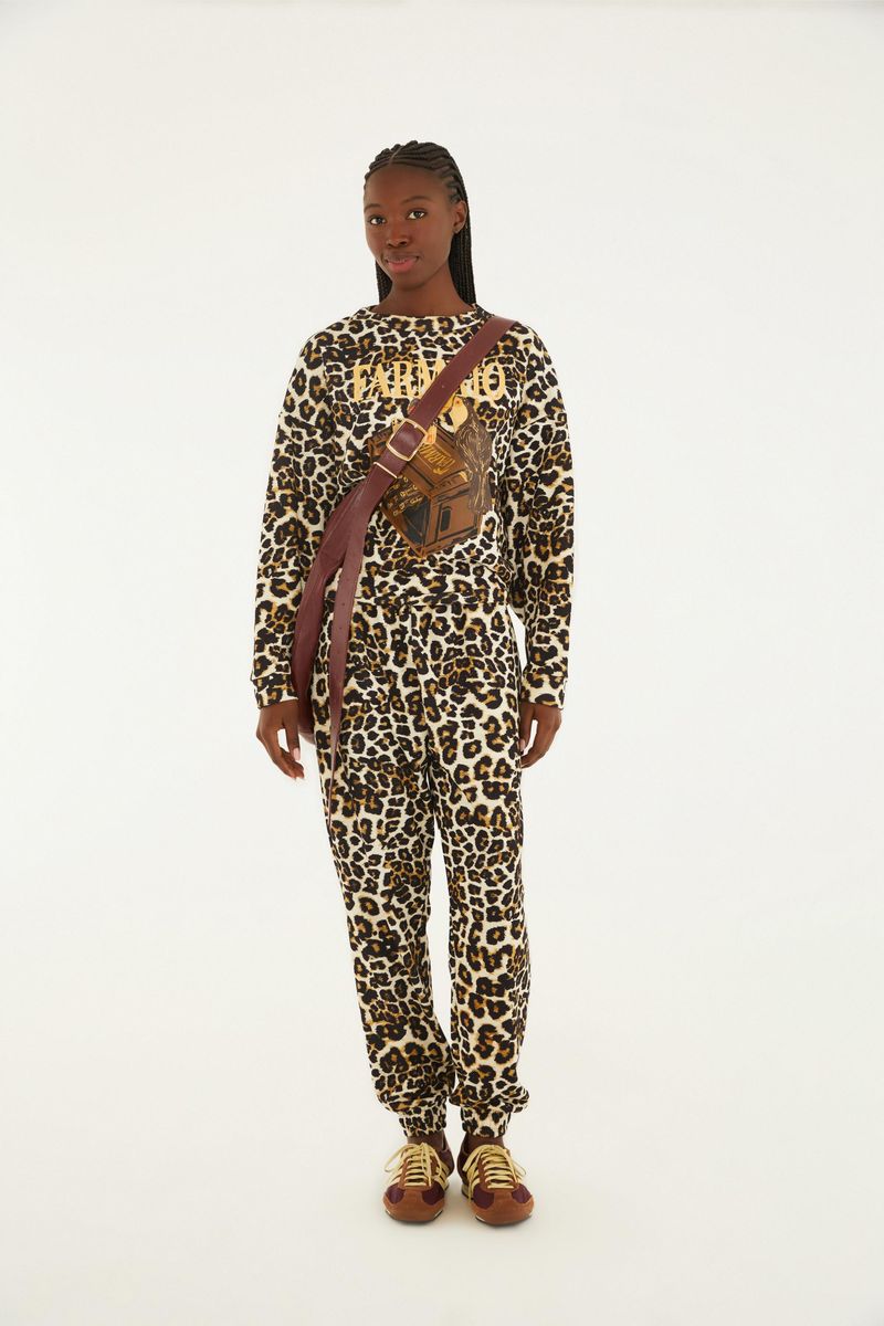 Vista frontal de un pantalón sudadera con estampado de leopardo, combinado con camiseta y zapatillas deportivas.