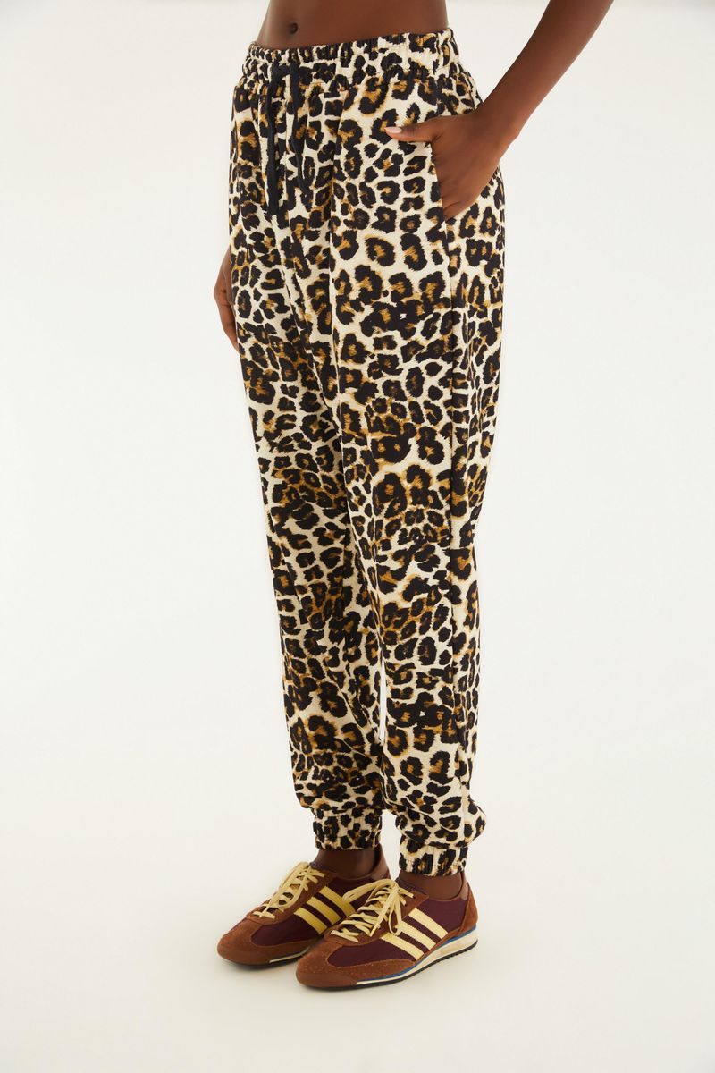 Detalle lateral del pantalón sudadera con estampado de leopardo, mostrando el ajuste cómodo.