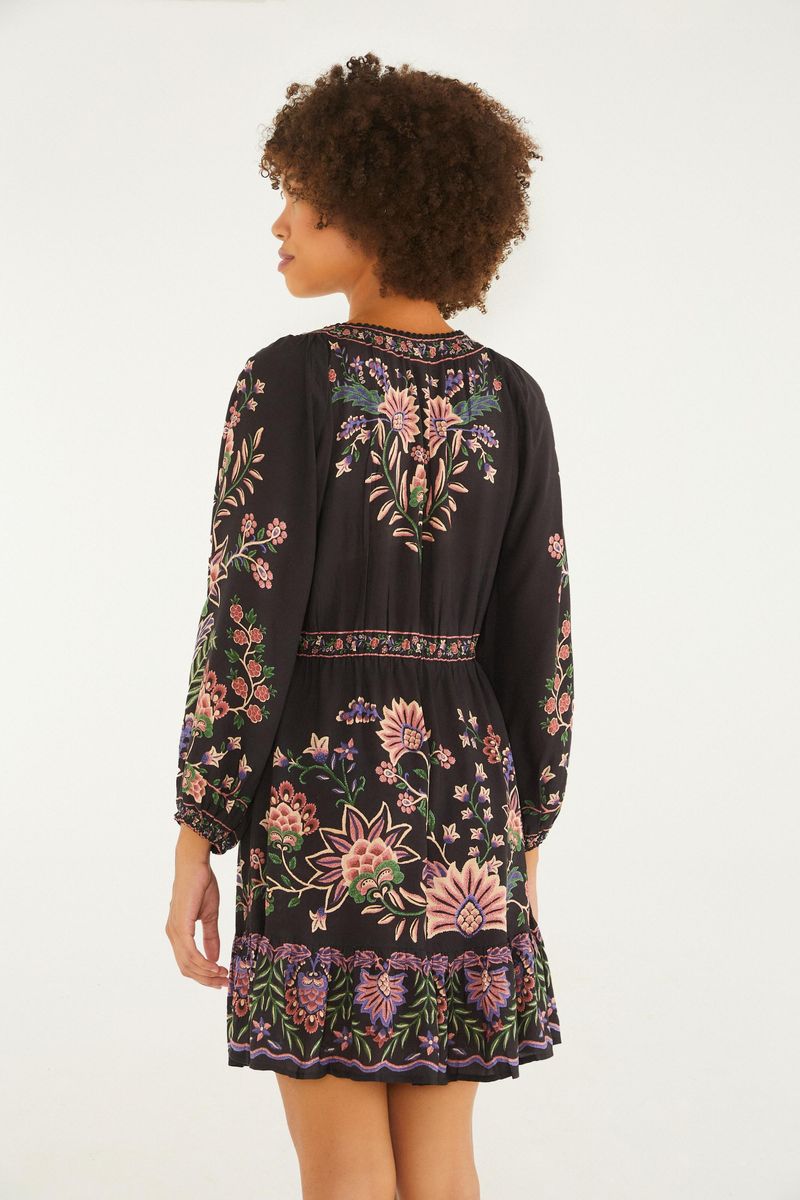 Vista trasera del vestido corto estampado con patrón floral y borde decorado.