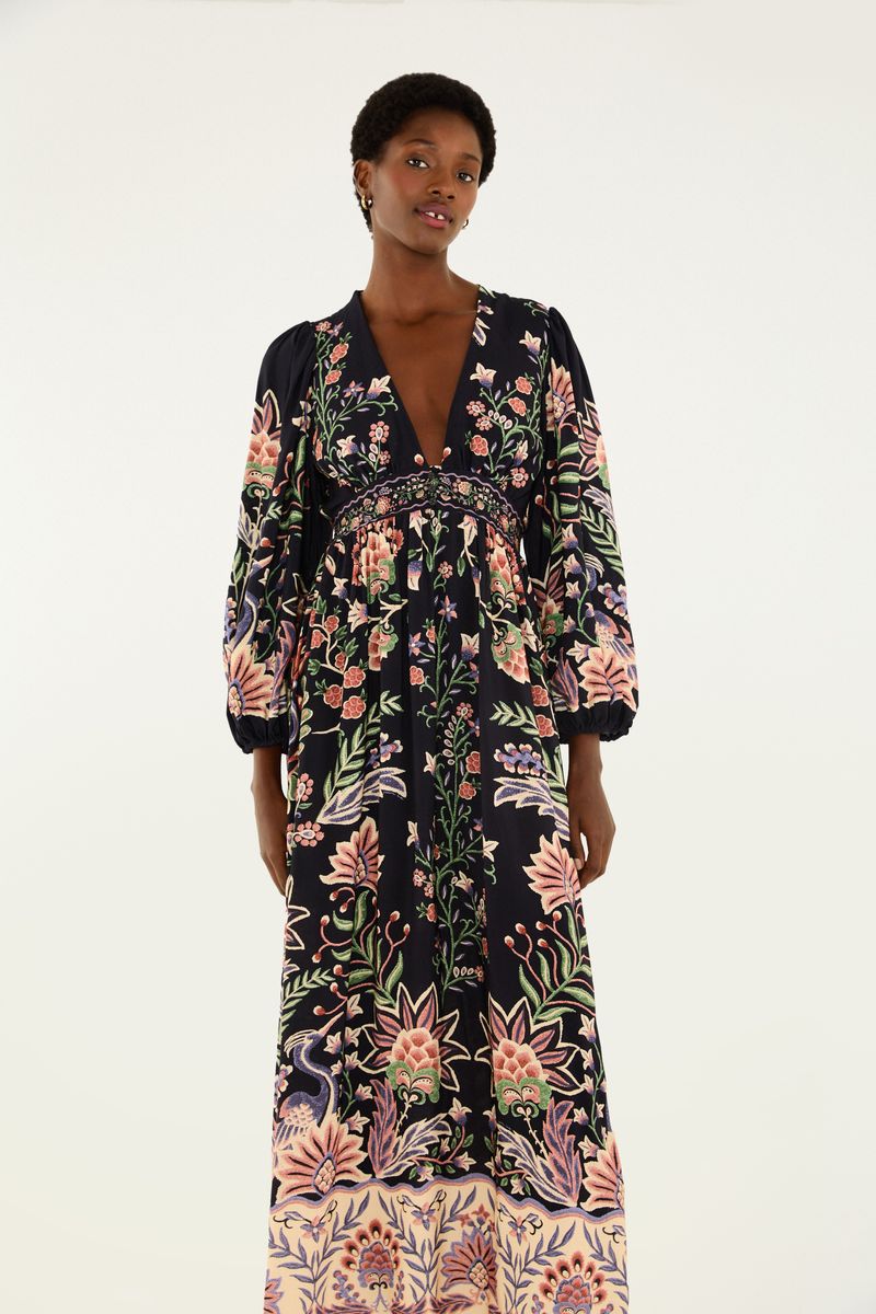 Vista lateral del vestido largo con estampado floral, destacando la caída fluida.