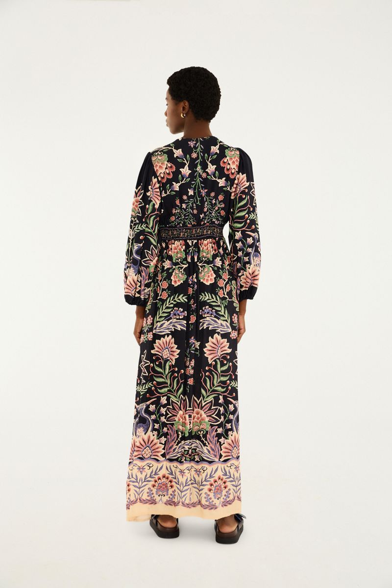Vista trasera del vestido largo con estampado floral, destacando el diseño de la parte posterior.