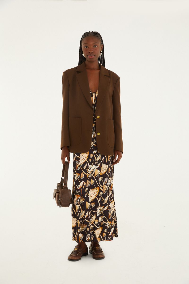 Vestido estampado con blazer marrón y bolso pequeño, mostrado en vista completa.