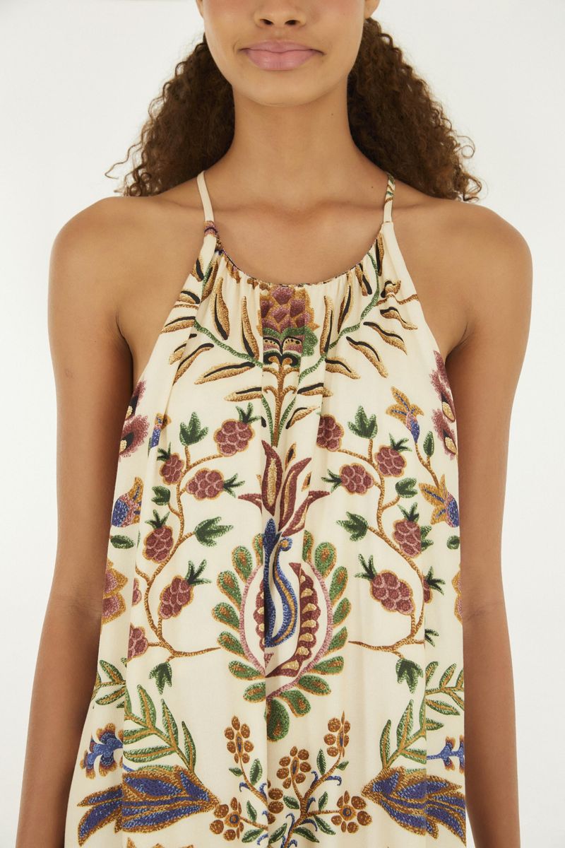 Primer plano del escote del vestido mostrando detalles del estampado botánico.