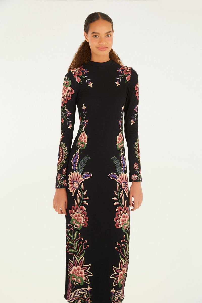Vestido midi con estampado floral sobre fondo negro, manga larga y cuello alto, visto de espaldas.