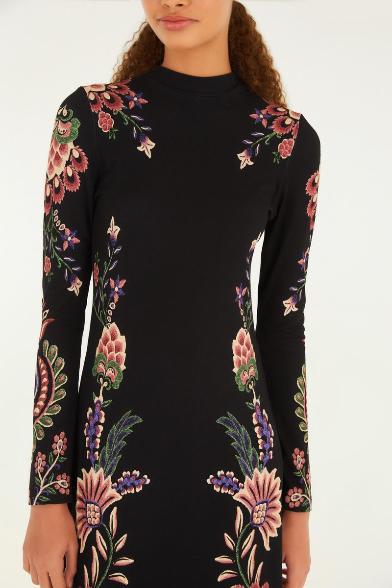 Detalle del vestido midi con estampado floral sobre fondo negro, mostrando el patrón floral y el cuello alto.