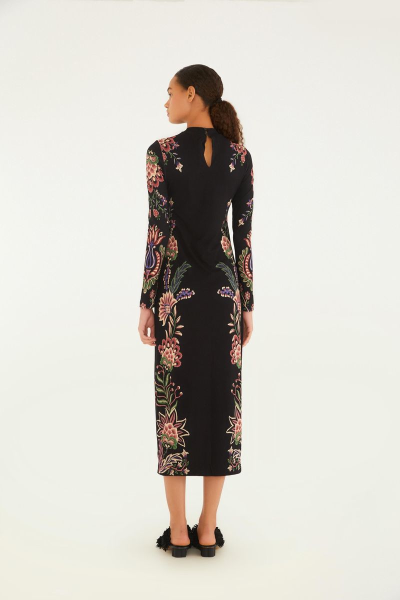 Vista lateral del vestido midi con estampado floral sobre fondo negro, destacando el ajuste al cuerpo.
