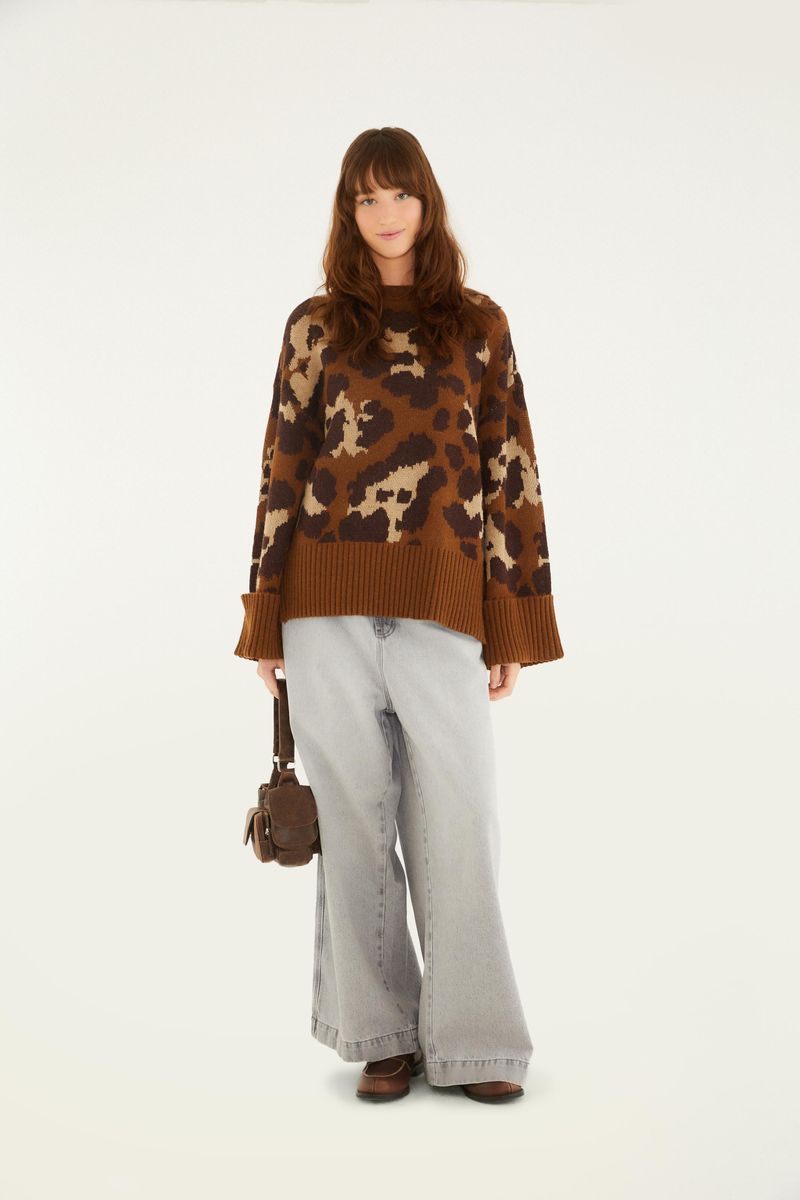 Modelo usando suéter de tejido de punto con estampado de leopardo, combinado con jeans.