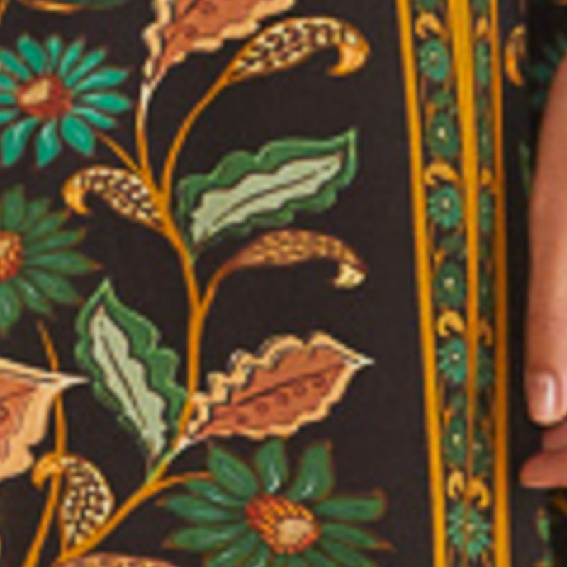Imagen mostrando el estampado botánico de la Falda Godé Marcelle con detalles de flores y hojas en tonos vibrantes sobre fondo oscuro.