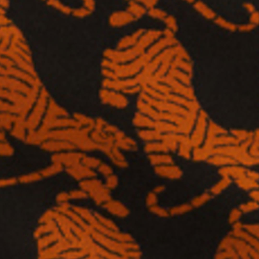 Imagen mostrando el diseño de tigres en tonos anaranjados sobre fondo negro de la Saia Cortita Tejido Tigres Copacabana.