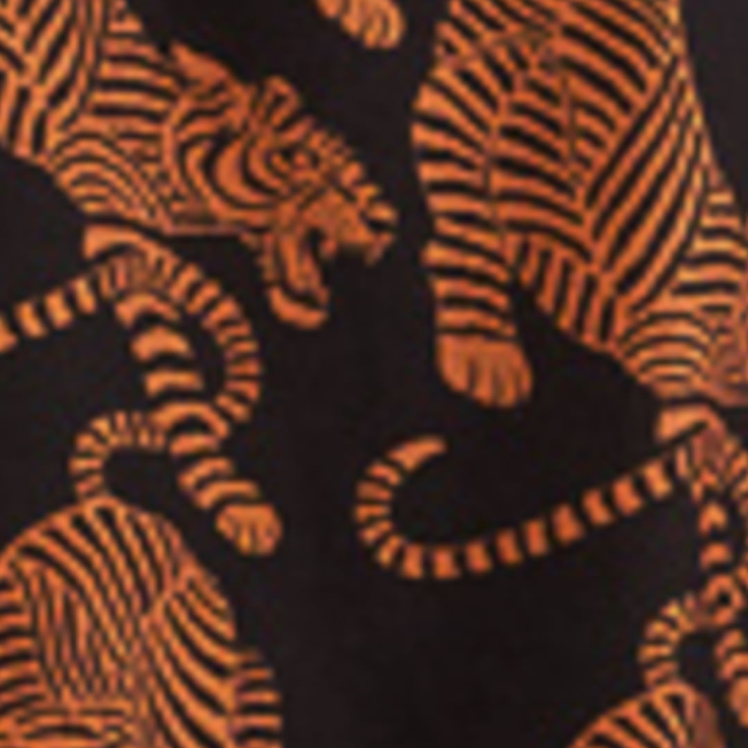 Detalle ampliado del estampado de tigres en tonos naranja sobre fondo negro.