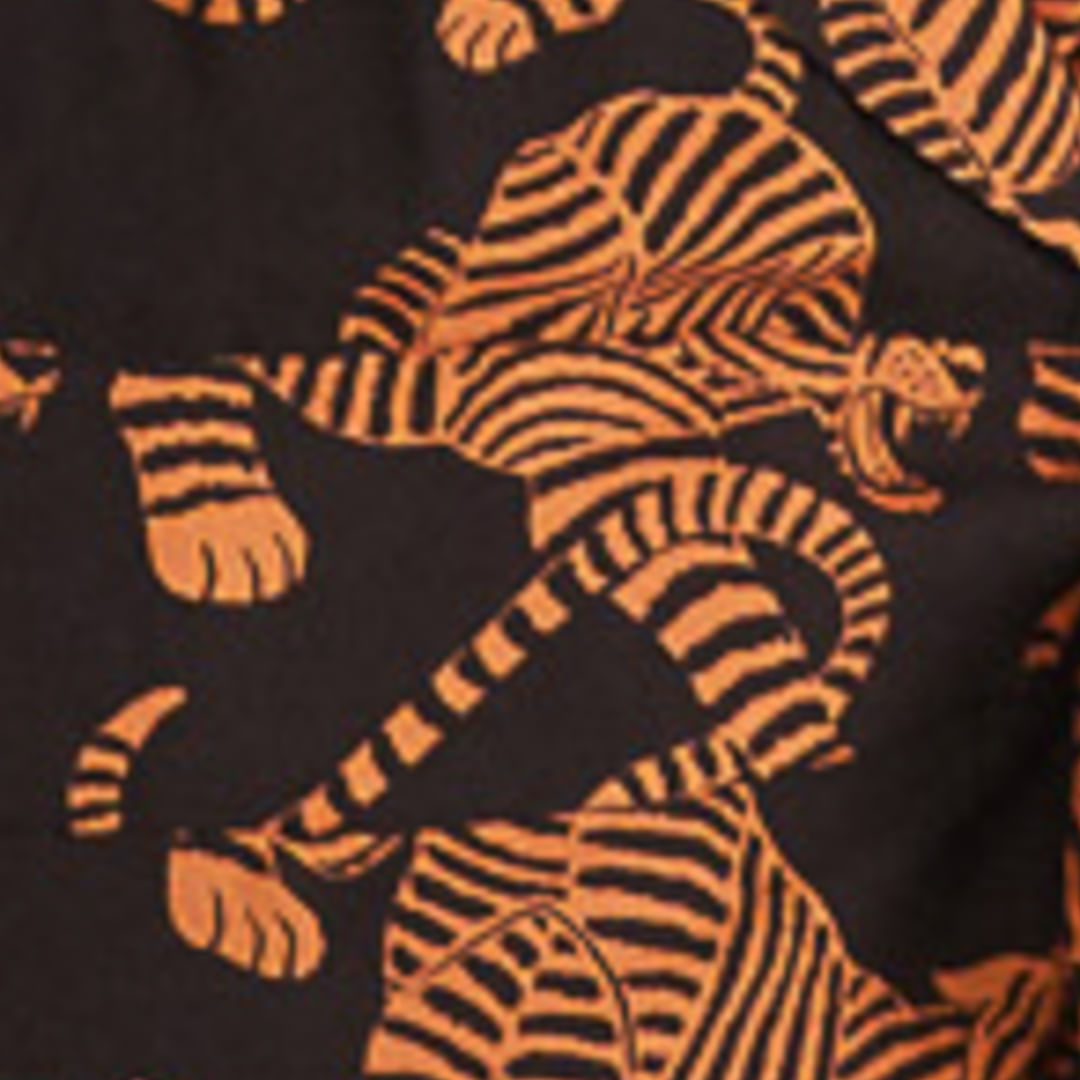 Acercamiento al estampado de tigres sobre fondo oscuro del vestido corto.