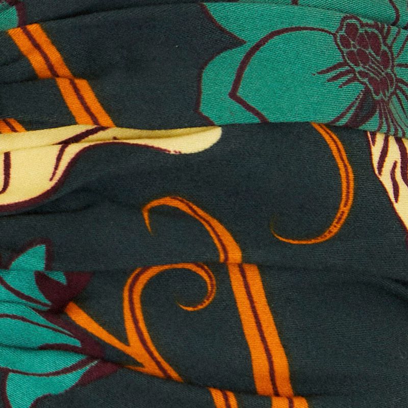 Detalle del estampado floral del vestido midi, con elementos botánicos en colores vibrantes.