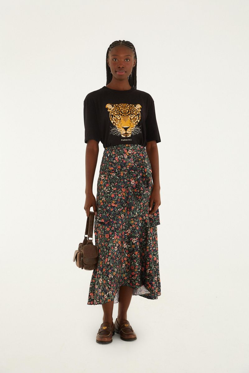Camiseta negra con estampado de leopardo combinada con falda floral.