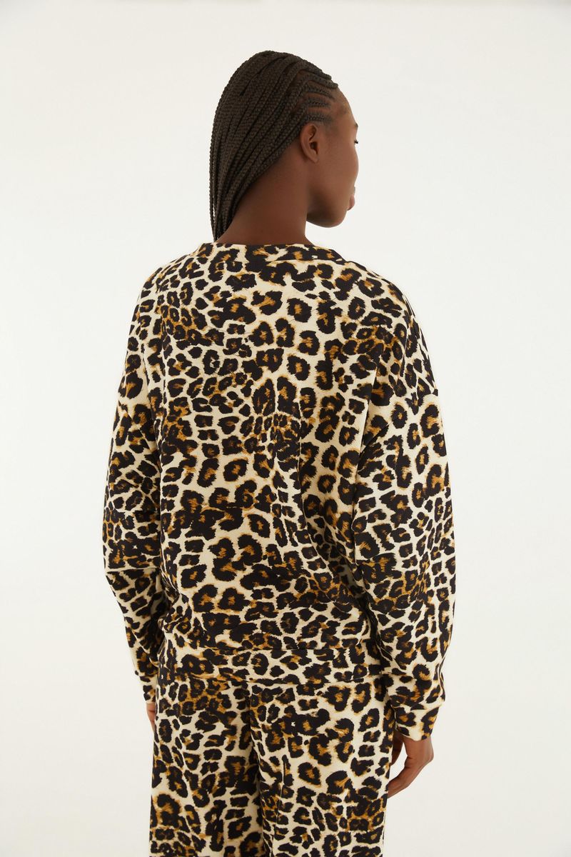 Vista lateral de la chaqueta de sudadera estampada con diseño de leopardo y detalles gráficos en la parte frontal.
