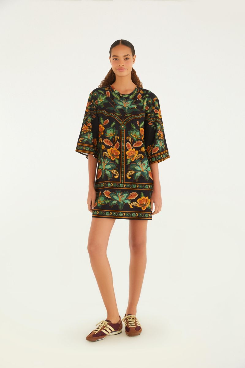 Vestido tipo camiseta con estampado floral vibrante sobre fondo negro, mostrado de cuerpo entero.