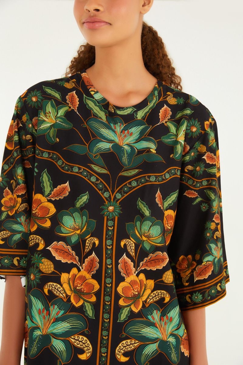 Detalle del escote redondo del vestido tipo camiseta con estampado floral vibrante.