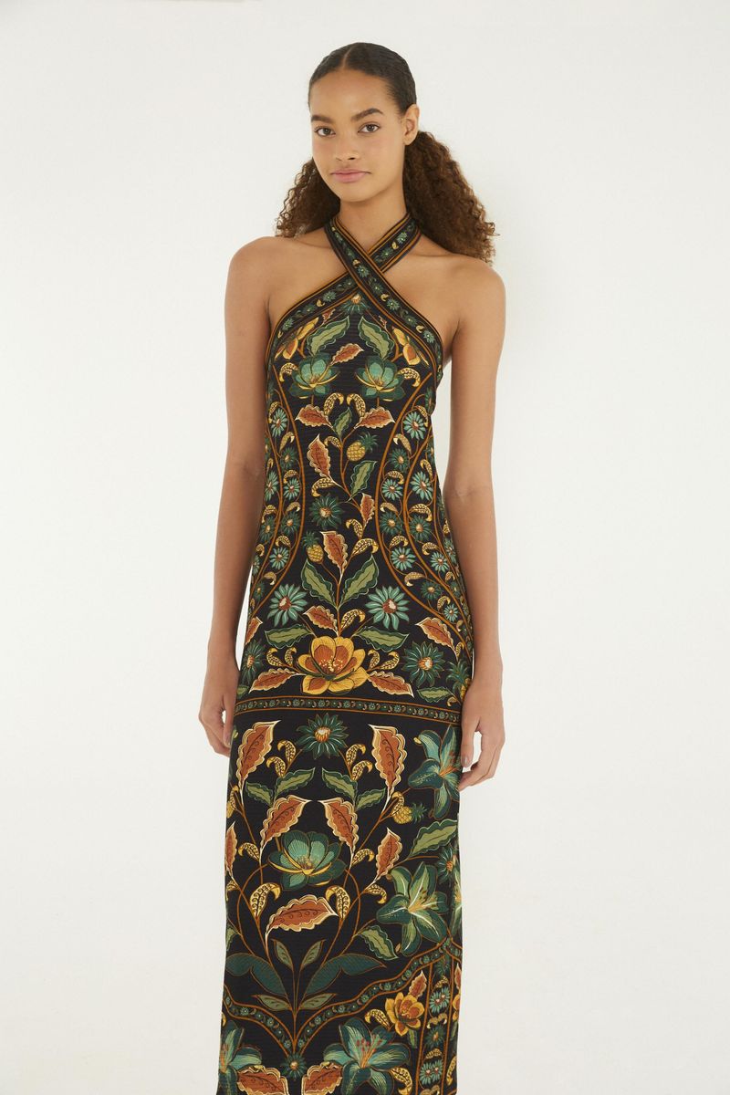 Vestido midi con estampado floral en fondo oscuro, tirantes cruzados y largo por debajo de la rodilla, visto desde atrás.