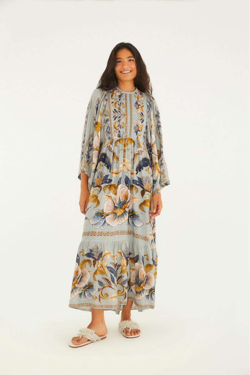 Vestido estampado con diseño floral y botánico, de largo recortado, mangas largas y detalles decorativos.