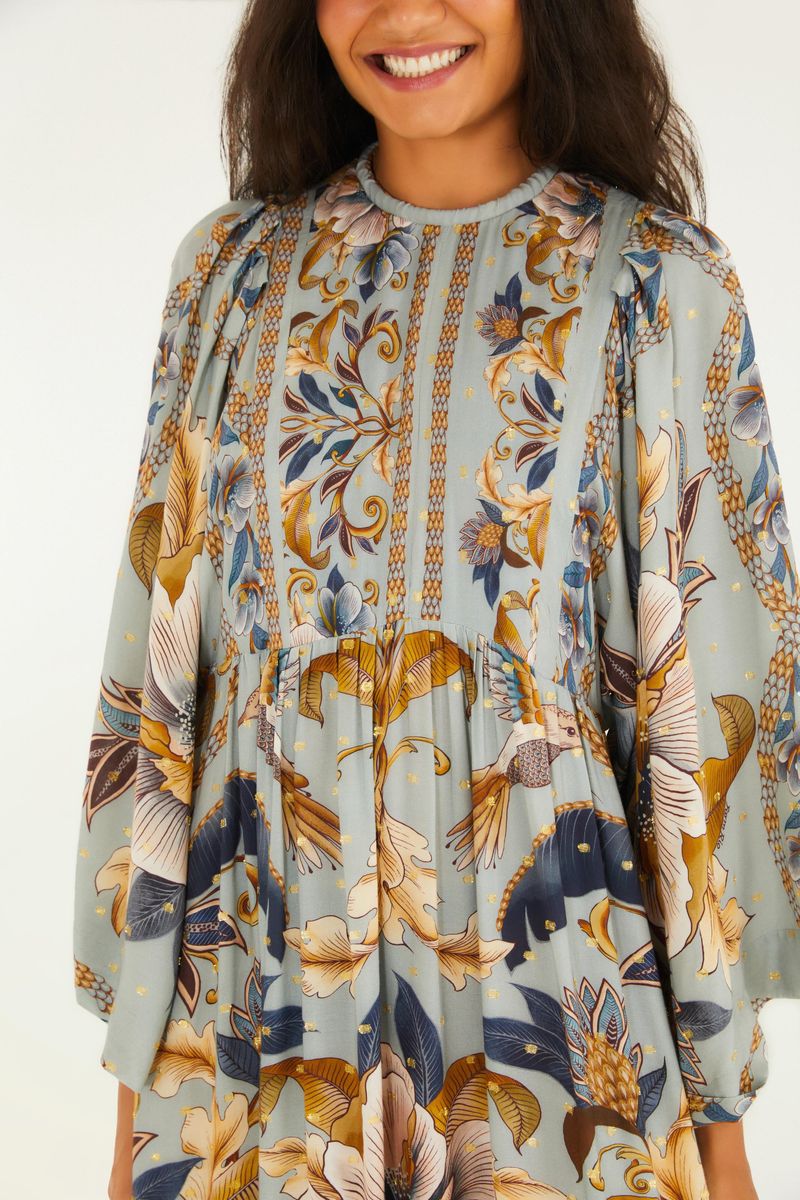 Primer plano del corpiño del vestido, destacando el diseño floral y botánico y el escote redondo.