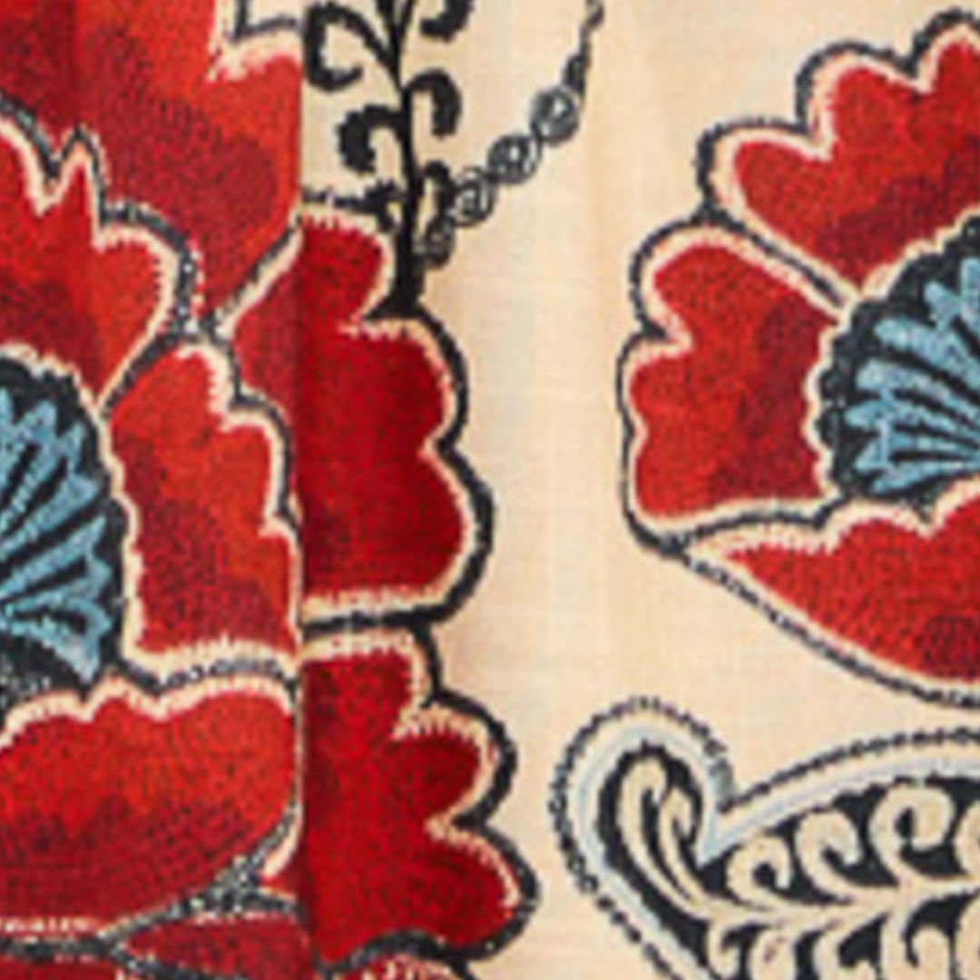 Imagen mostrando un detalle del tejido del vestido corto Francisca, con estampado floral en tonos de rojo, azul y beige.