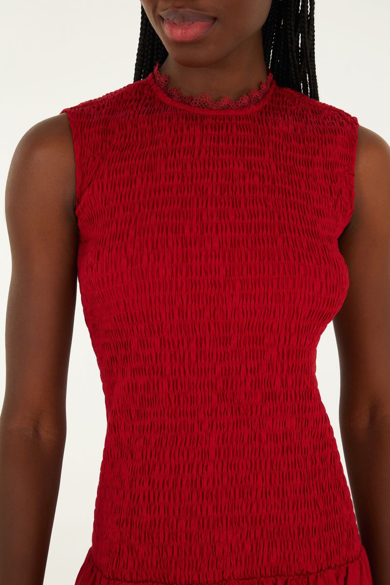 Detalle del tejido rojo con textura y bordados en forma de corazón.