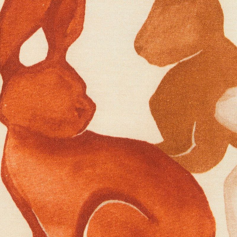 Primer plano del estampado de conejos en tonos cálidos del vestido.