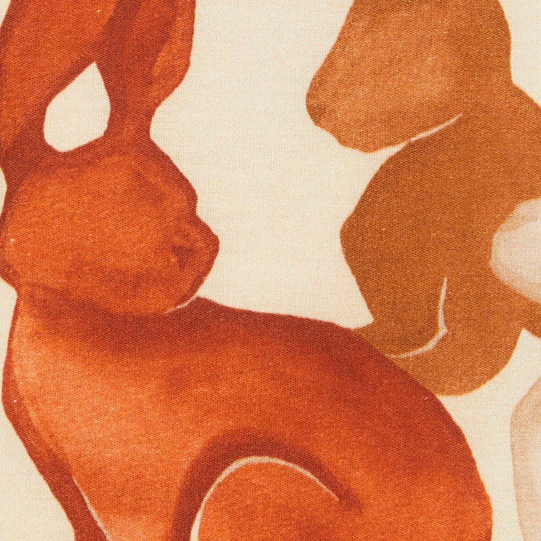 Primer plano del estampado de conejos en tonos cálidos del vestido.