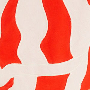 Detalle de la falda del vestido largo con estampado abstracto en rojo y blanco, evidenciando el patrón ondulado.