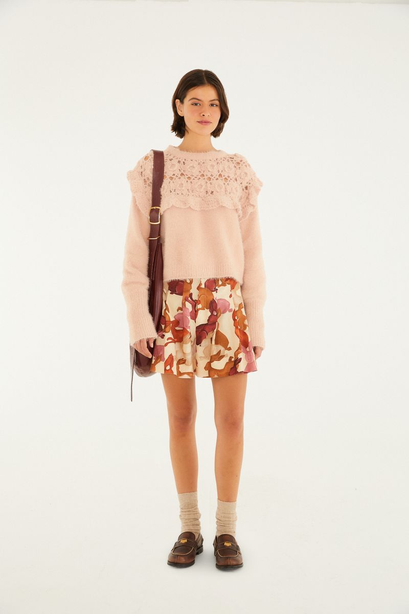Imagen de una modelo vistiendo una bermuda con pliegues y estampado de conejos, combinada con una blusa rosada.