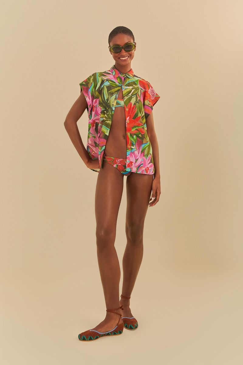 Modelo usando un bikini estampado con camisa tropical abierta.