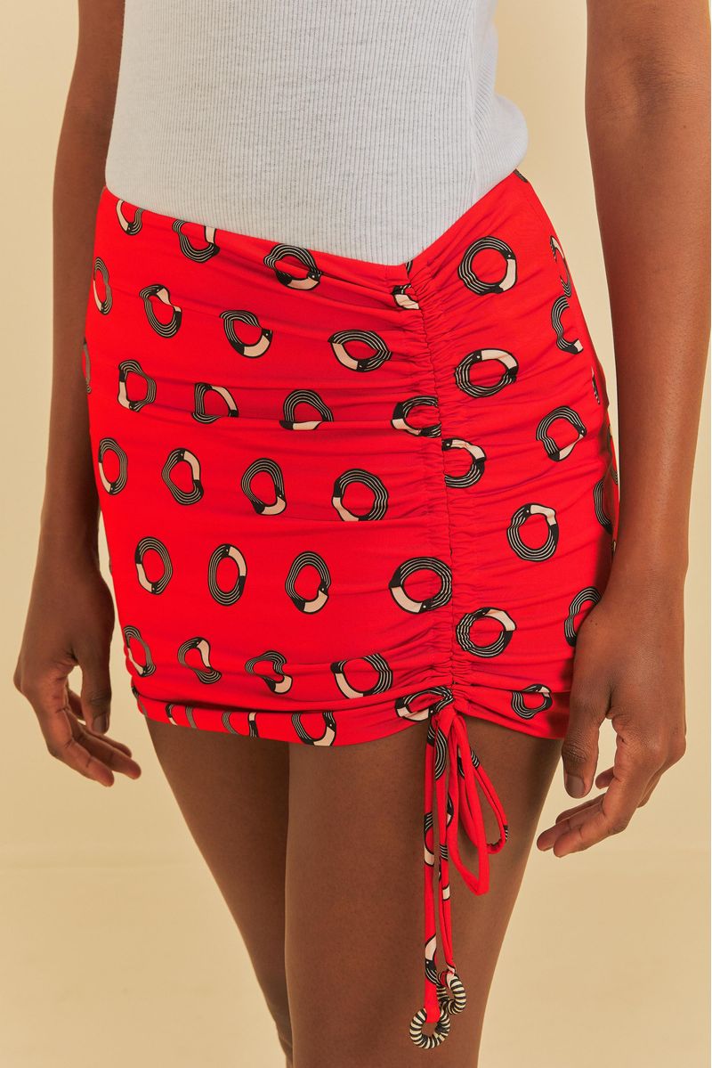 Detalle lateral de la mini falda roja con cordón y estampado geométrico.