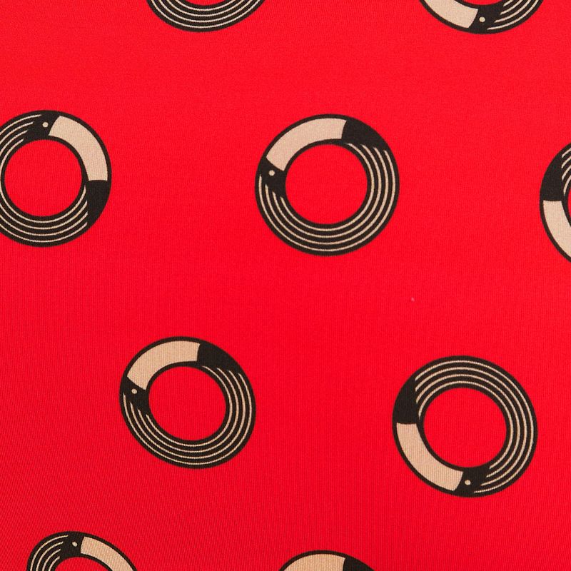 Primer plano del estampado geométrico sobre fondo rojo de la mini falda.