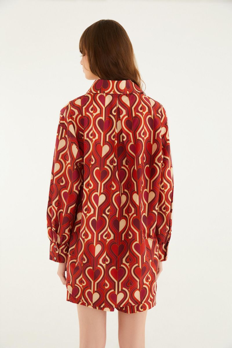 Vista trasera de la camisa estampada con diseño geométrico en tonos de rojo y beige.