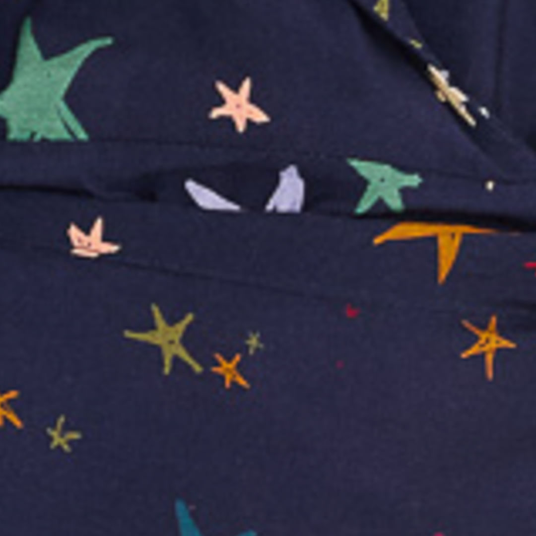 Close-up del estampado de estrellas multicolores en el tejido del vestido corto.