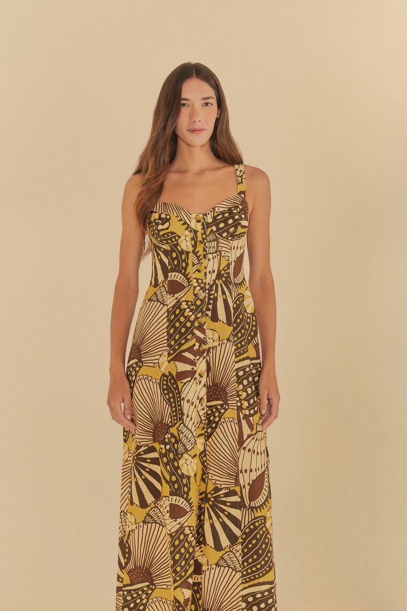 Imagen de un vestido corto con estampado tropical en tonos de amarillo y marrón, visto de lado.