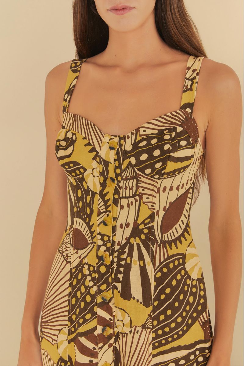 Imagen de un vestido corto con estampado tropical en tonos de amarillo y marrón, con detalle del corpete.