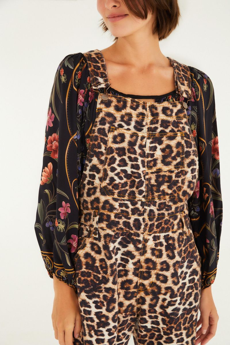 Detalle del overol estampado con patrón de leopardo, mostrando el escote y las tiras.