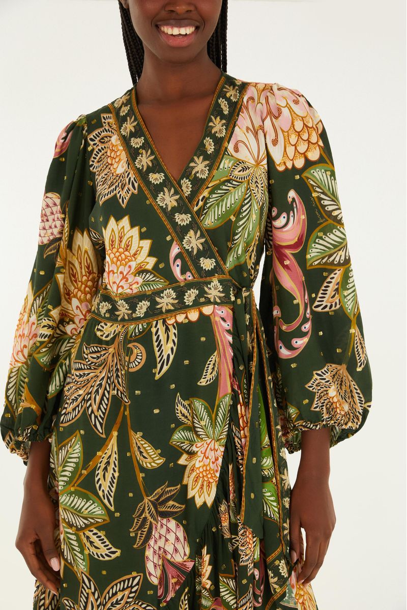 Detalle del vestido mostrando el estampado floral con elementos botánicos y ajuste en la cintura.