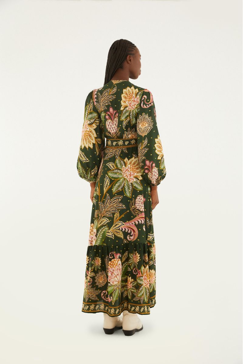 Vista trasera del vestido largo con estampado floral, destacando la caída fluida y el borde decorado.