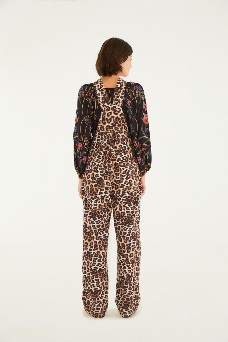 Overol estampado con patrón de leopardo, visto desde atrás, combinado con blusa floral.