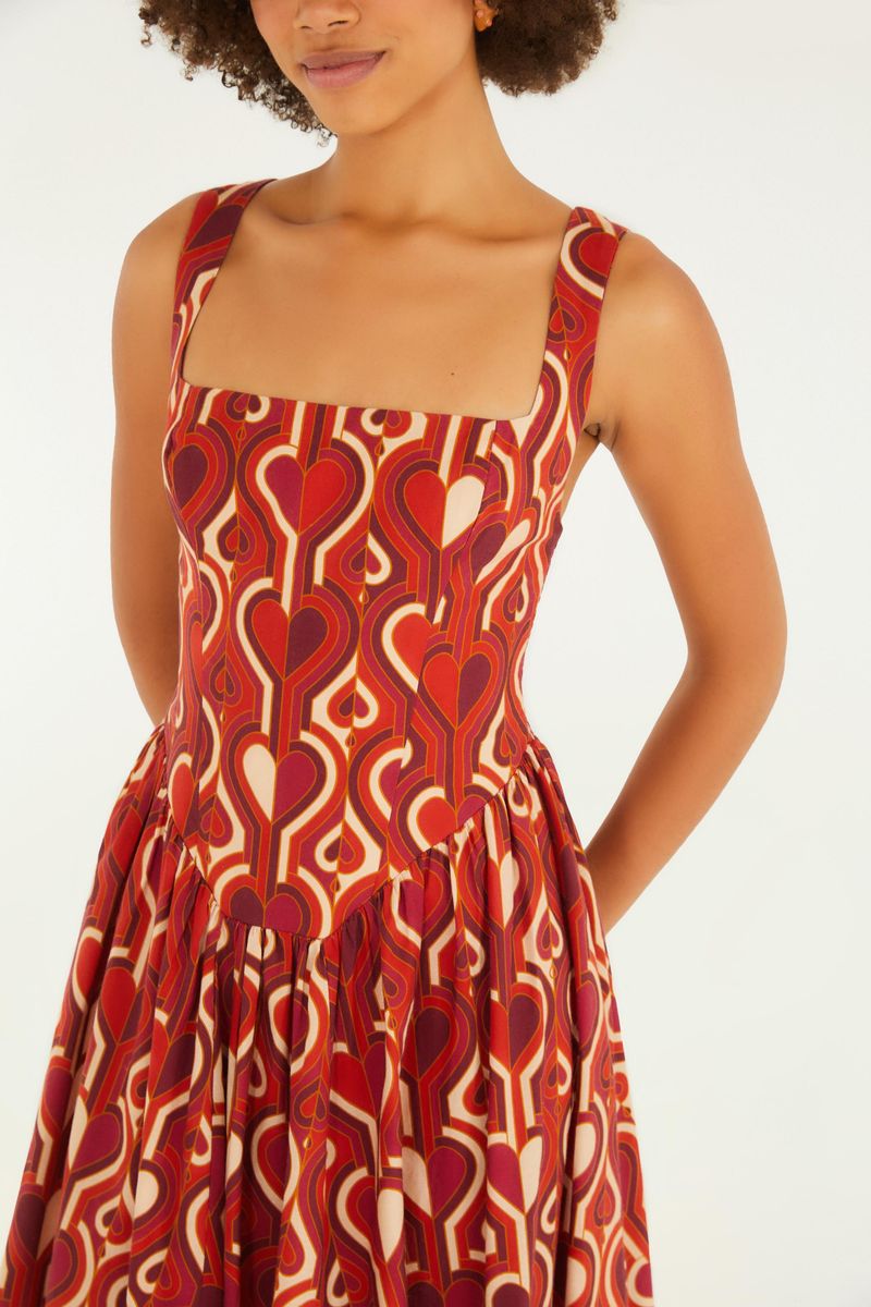 Primer plano del corset de un vestido estampado con patrón geométrico en tonos de rojo y blanco.