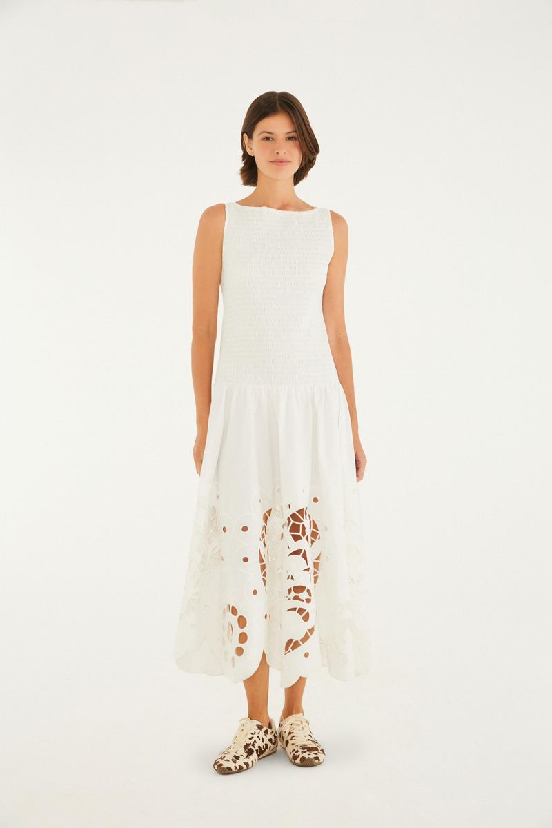 Vestido blanco con detalles bordados en forma de corazón en la parte inferior, visto de frente.