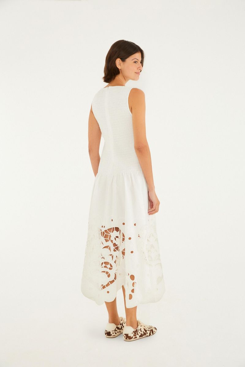 Vista lateral del vestido blanco con detalles bordados en forma de corazón en la parte inferior.