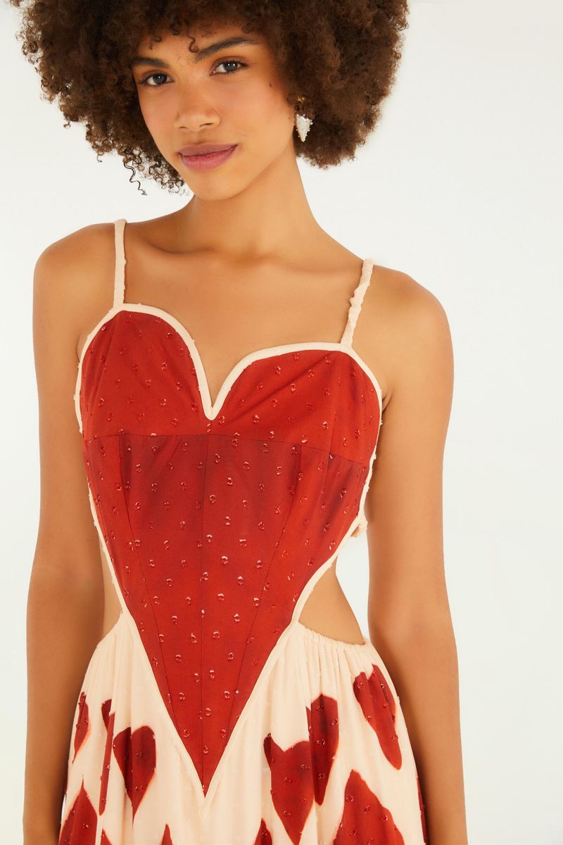 Detalle del corsé del vestido maxi con estampado de corazones rojos, mostrando el escote en forma de corazón y acabado delicado.