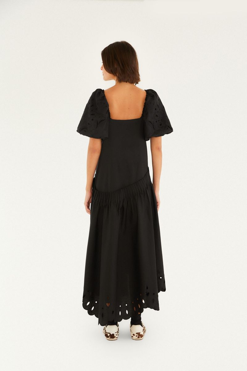 Vestido negro con bordado Richelieu, manga abullonada y longitud larga, visto de espaldas.